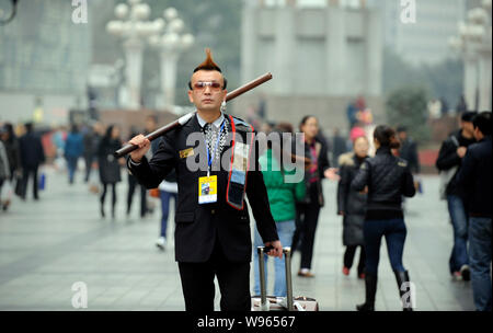 Zhou Fei, wie die Angesagtesten Bettler in China bekannt ist, stellt in einer Fußgängerzone in Chongqing, China, 23. Februar 2012. Anzug, gespritzt Stockfoto