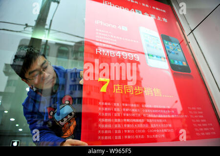 Ein chinesischer Mitarbeiter fügt ein Werbeplakat des iPhone 4S Smartphone bei einem autorisierten Apple Store in Kunshan City, Central China Provinz Hubei, Stockfoto