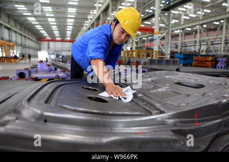 ---- Ein chinesischer Arbeiter, der Stäube aus Auto Teile an die automatische Anlage von JMC (Jiangling Motors Co., Ltd.) in Nanchang City, East China Jiangxi prov Stockfoto