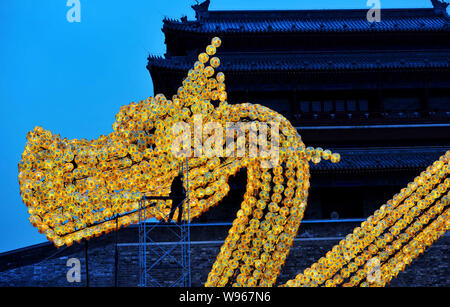 Ein chinesischer Arbeiter legt letzte Hand an einen riesigen Drachen mit mehr als 3.000 Laternen, welche Maßnahmen 39.06 m lang, 7.01 m breit und 13.2. Stockfoto