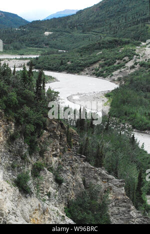 Ein gewundener Fluss schneiden seinen Weg durch die schöne bewaldete Berge im Denali National Park, Alaska, USA. Beachten Sie die Eisenbahnschienen. Stockfoto