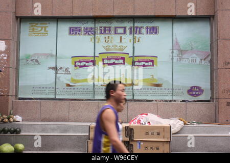 ---- Fußgänger vorbei an einer Werbung für Synutra Milchpulver in Chongqing, China, 1. Mai 2011. Amtliche Lebensmittel Tests haben bewiesen, dass eine gut Stockfoto