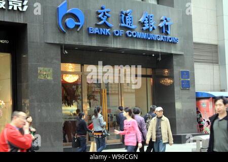 ---- Fußgänger vorbei an eine Filiale der Bank of Communications (BoCom) in Chongqing, China, 28. März 2012. Bank von Communications Corp., der Graf Stockfoto