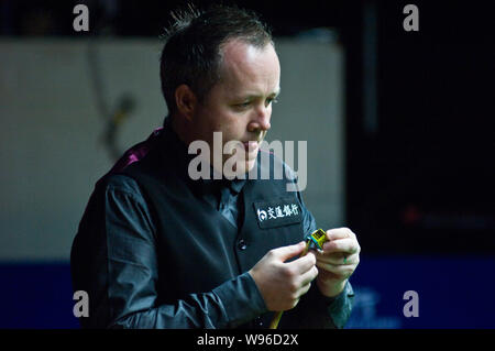 John Higgins von Schottland Kreiden sein Stichwort, wie er gegen Ryan Day von Wales in der zweiten Runde der World Snooker Shanghai Masters 2012 in konkurriert Stockfoto