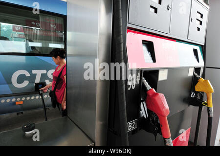 ---- Eine chinesische Fahrer tankt ihr Bus an einer Tankstelle in der Stadt Sanming, südost China Fujian Provinz, 19. Mai 2012. China will Benzin re Stockfoto