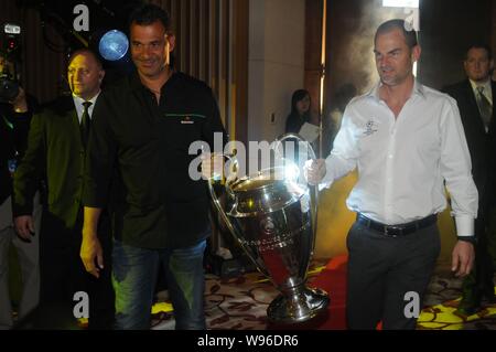 Ehemalige niederländische Fußball-Stars Ruud Gullit (L) und Ronald De Boer halten sie die Trophäe während einer fördernden Tätigkeit für die UEFA Champions League in Shanghai, Kinn Stockfoto