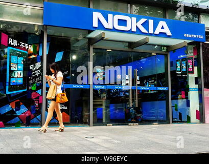 ---- Ein Fußgänger geht hinter einem Nokia Store in Shanghai, China, 9. Juni 2012. Finnische Handyhersteller Nokia hat seinen zu verkleinern Stockfoto