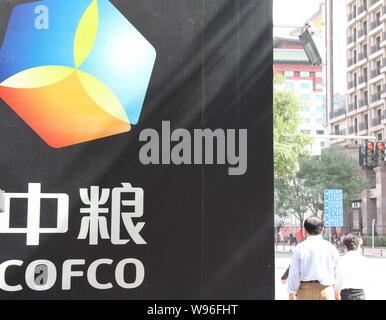 ---- Fußgänger vorbei an einer Anschlagtafel von COFCO in Peking, China, 29. September 2011. China National Getreide, Öle und Lebensmittel Corporation (CO Stockfoto