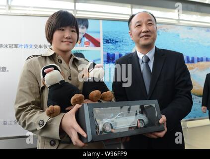 Chinesischen Olympischen Swimmingpool Meister Ihr Shiwen, Links, ist Spielzeug Hunde und ein Modell auto während einer Zeremonie an einem BMW Dealership in Hangzhou ci dargestellt Stockfoto