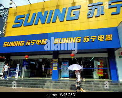 ---- Ein Fußgänger geht hinter einem suning Home Appliances speichern in Shanghai, China, 16. August 2011. Suning, China führender Einzelhändler der Home ap Stockfoto