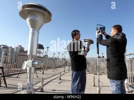 Chinesische Umweltüberwachung Arbeiter Gerät installieren zu PM2,5 (Feinstaub bis 2,5 Mikrometer im Durchmesser) auf einer Überwachungsstation erkennen Stockfoto