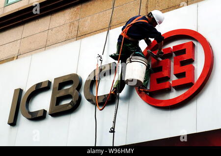 ---- Ein Arbeiter reinigt die Beschilderung von ICBC (Industrie- und Handelsbank von China) bei einer Niederlassung in Shanghai, China, 9. Mai 2012. Eine Gruppe von Chinesischen Stockfoto