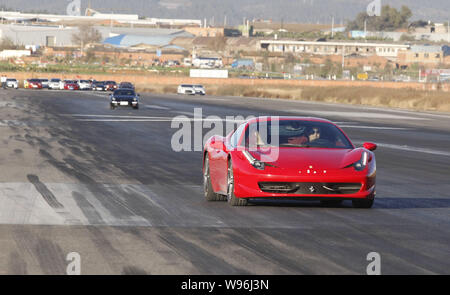 Ein Ferrari 458 Italia und andere Supercars Rennen auf der Start- und Landebahn während einer Testfahrt an der Kunming Wujiaba zum Internationalen Flughafen Kunming City, southwes Stockfoto