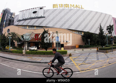 Ein Mann fährt mit dem Fahrrad hinter dem neuen South China Mall in Dongguan City, South China Guangdong Provinz, 9. April 2012. Die neuen South China Mall in Donggu Stockfoto