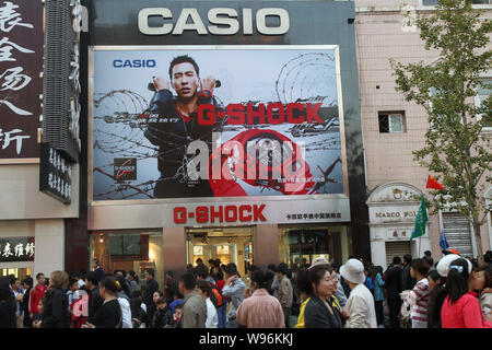 ---- Fußgänger vorbei an einer Anschlagtafel der Casio in Peking, China, 3. Oktober 2011. China online shopping site, dangdang.com, hat vorgeworfen worden Stockfoto