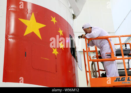 Eine chinesische Luft- und Raumfahrt Ingenieur überprüft die Verkleidung des Shenzhou Shenzhou-9 (IX) Satelliten im Jiuquan Satellite Launch Center in der Nähe von jiuquan Stadt, n Stockfoto