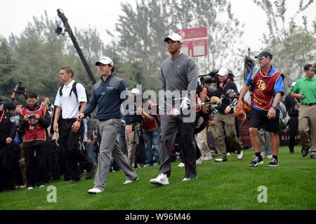 Rory McIlroy von Nordirland, der vordere linke und der Tiger Woods der Vereinigten erklärte, vorne rechts, Weg, während das Duell an der Jinsha Lake Golf Ausstellung m Stockfoto