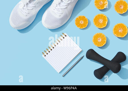 Sport flach mit Fitnessgeräten und Zubehör auf blauem Hintergrund Stockfoto