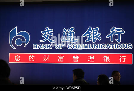 ---- Fußgänger vorbei an einer Anschlagtafel der Bank von Kommunikation in Suzhou City, East China Jiangsu Provinz, 10. Januar 2012. Bank von Kommunika Stockfoto