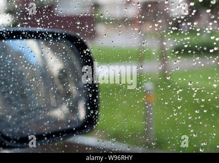 Regentropfen auf dem Auto Glas während des Tages Stockfoto