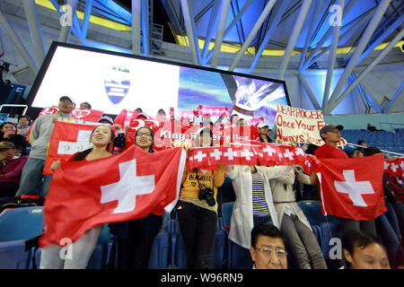 Tennis Fans halten schweizer Fahnen Unterstützung für Roger Federer von der Schweiz zu zeigen, wie er gegen Stanislas Wawrinka aus der Schweiz in ihrem dritten konkurriert Stockfoto