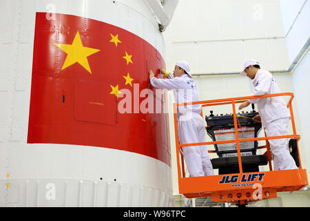 Eine chinesische Luft- und Raumfahrt Ingenieur überprüft die Verkleidung des Shenzhou Shenzhou-9 (IX) Satelliten im Jiuquan Satellite Launch Center in der Nähe von jiuquan Stadt, n Stockfoto