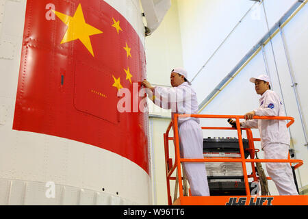 Eine chinesische Luft- und Raumfahrt Ingenieur überprüft die Verkleidung des Shenzhou Shenzhou-9 (IX) Satelliten im Jiuquan Satellite Launch Center in der Nähe von jiuquan Stadt, n Stockfoto