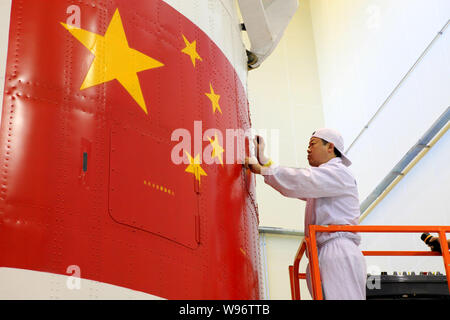 Eine chinesische Luft- und Raumfahrt Ingenieur überprüft die Verkleidung des Shenzhou Shenzhou-9 (IX) Satelliten im Jiuquan Satellite Launch Center in der Nähe von jiuquan Stadt, n Stockfoto