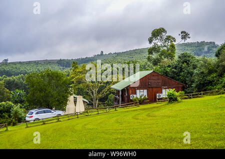 Ein wunderschönes Blockhaus Haus in Sabie Südafrika mit Blick auf den einheimischen Wald und grünen Garten anmelden Stockfoto