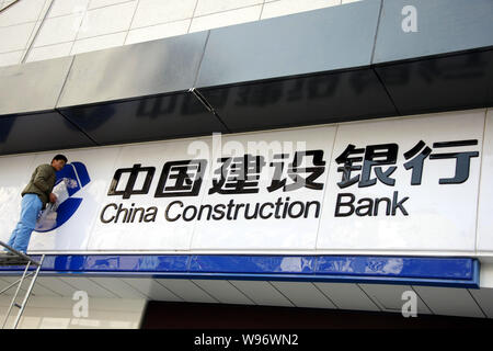 ---- Ein chinesischer Arbeiter Stäube aus der Tafel in einer Filiale der China Construction Bank (CCB) in Stadt Huaibei, East China Provinz Anhui, 26. März 20 Stockfoto