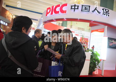 ---- Menschen besuchen den Stand der PICC (Peoples Insurance Company von China) während der Expo in Peking, China, 3. November 2011. China staatseigene i Stockfoto