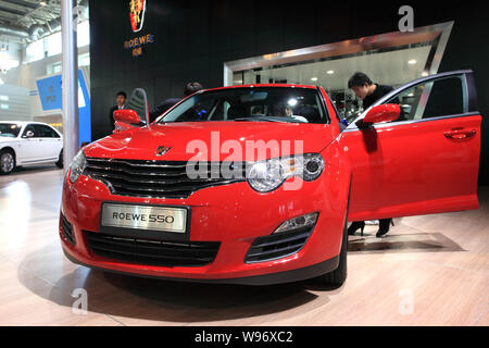 ---- Besucher an einem Roewe 550 der SAIC schauen während der Auto Show in Peking, China, 24. April 2010. Shanghai - Gelistet SAIC Motor Corp verkündet Tuesda Stockfoto