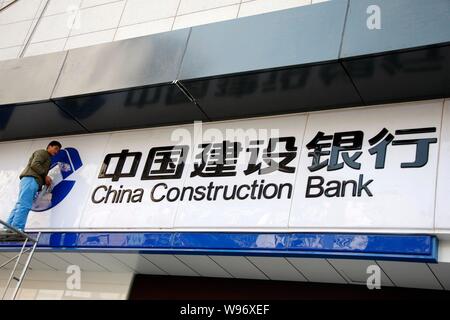 ---- Ein chinesischer Arbeiter Stäube aus der Tafel in einer Filiale der China Construction Bank (CCB) in Stadt Huaibei, East China Provinz Anhui, 26. März 20 Stockfoto