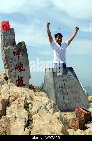 Chinesische beinlose Mann chen Zhou Wellen seine Hände zu feiern das Erreichen der Junji Gipfel des Songshan Berg in Dengfeng, Zentrale China Provinz Henan, 12. Stockfoto