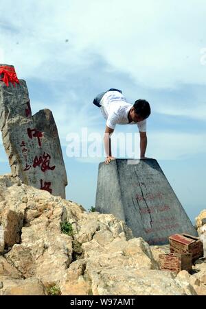 Chinesische beinlose Mann chen Zhou steht auf seinen Händen zu feiern das Erreichen der Junji Gipfel des Songshan Berg in Dengfeng, Zentrale China Provinz Henan Stockfoto