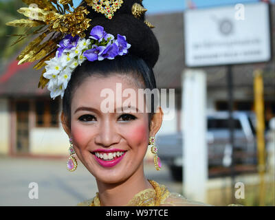 Kostümierte schöne Thai Mädchen mit Blumen im Haar nimmt Teil an der Geschichte des Dorfes Lanna street parade und Lächeln für die Kamera. Stockfoto