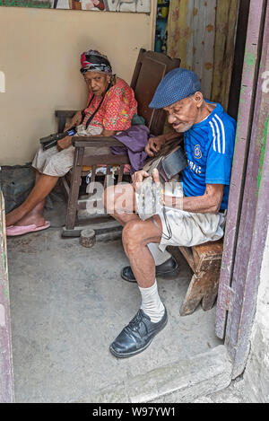 Havanna, Kuba - April 09, 2019: in einer alten Stadt Tür, ein älterer Mann spielt eine Gitarre wie eine ältere Frau Uhren Stockfoto
