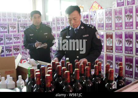 ------ Chinesische Polizeibeamte fake Wein in einem Geschäft in Shenyang konfiszieren, Provinz Liaoning im Nordosten Chinas, den 7. Mai 2011. Der Senat Arme Stockfoto