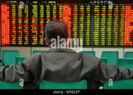 Ein Chinesischer Investor schaut bei Aktienkursen (grün für Preis fallend) an einem Lager Brokerhaus in Dalian in der Provinz Liaoning im Nordosten Chinas, 23 Septem Stockfoto