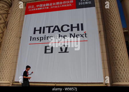 ---- Fußgänger vorbei an einer Werbung für Hitachi in Peking, China, 2. September 2011. China sagte Western Digital Corp. muss Konzert Adresse Stockfoto