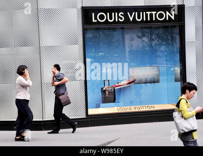 Menschen gehen vorbei an einer Louis Vuitton (LV) Boutique in Nanjing City, East China Jiangsu Provinz, 16. Juni 2011. China, bereits die Weltzweitgroessten Stockfoto