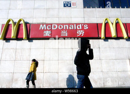 ------ Anwohner vorbei an das Logo von MCDONALD'S in Peking, China, 18. Oktober 2010. Da schiebt er seinen Fokus auf China, McDonalds berichtet. Stockfoto