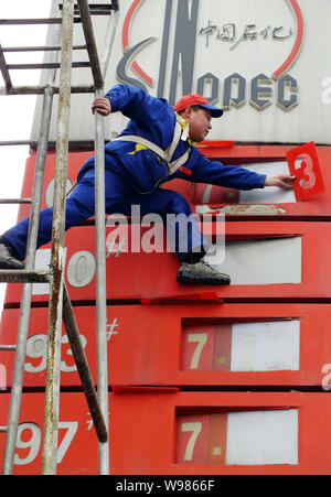 Ein chinesischer Arbeiter aktuelles Treibstoffpreise an einer Tankstelle von Sinopec in Kunshan City, Central China Provinz Hubei, 7. April 2011. China, Asias größte Stockfoto