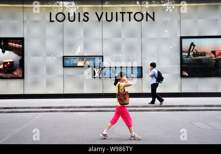 Menschen gehen vorbei an einer Louis Vuitton (LV) Boutique in Nanjing City, East China Jiangsu Provinz, 16. Juni 2011. China, bereits die Weltzweitgroessten Stockfoto