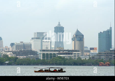 ------ Touristische boote Segeln auf dem West See gegen die Skyline von Hangzhou City, East China Zhejiang provinz, 13. April 2009. Hangzhou Behörden Stockfoto