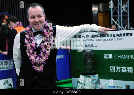 John Higgins von Schottland stellt seine Trophäe bei der Preisverleihung nach dem Finale der Internationalen Snooker Classic 2011 in Qionghai Stadt, Stockfoto