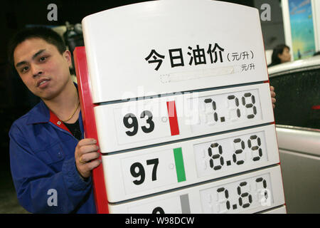 Ein chinesischer Arbeiter aktuelles Treibstoffpreise nach Mitternacht an einer Tankstelle in Shanghai, China, 7. April 2011. China, Asias größten Ölverbraucher, angehoben Stockfoto