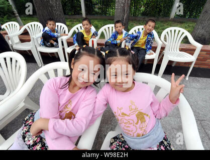 Ein Paar von zwei Mädchen und vier quadruplet Jungen sind dargestellt, während einer Pressekonferenz für die 8 Peking Zwillinge Cultural Festival in Peking, China, 12. Stockfoto