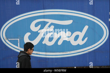 ---- Ein Fußgänger geht Vergangenheit ein Logo von Ford in Qingdao, Provinz Shandong, China vom 11. Dezember 2011. Nach seiner jüngsten Motor und Getriebe Stockfoto