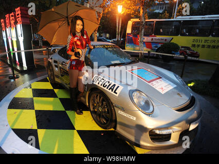 Ein Modell stellt bei einem Porsche Wagen an Xintiandi Plaza in Wuhan, China, Provinz Hubei, 30. September 2011. 50 Porsche Fahrzeuge wurden an Xintian geparkt Stockfoto